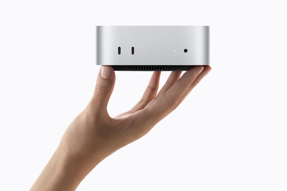 Mac mini đặt trên bàn cùng màn hình máy tính