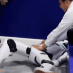 Robot hình người nằm trên sàn triển lãm sau khi gặp sự cố