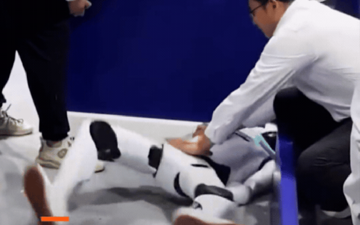 Robot hình người nằm trên sàn triển lãm sau khi gặp sự cố