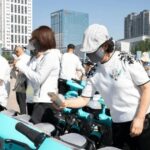 Người dùng mở khóa xe hai bánh màu xanh bằng mã QR trên ghi-đông