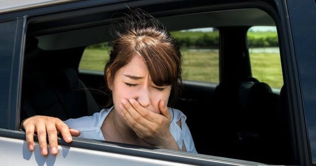 Hành khách ngồi trong ô tô với biểu hiện khó chịu vì say xe