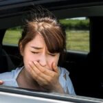 Hành khách ngồi trong ô tô với biểu hiện khó chịu vì say xe
