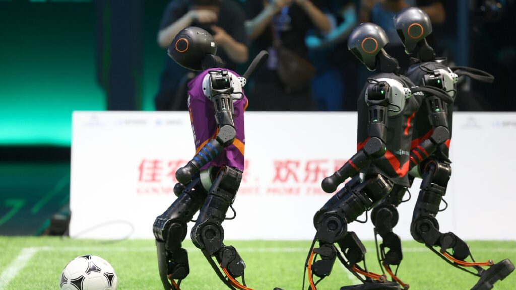 Robot Booster T1 di chuyển và xử lý bóng trong sân thi đấu