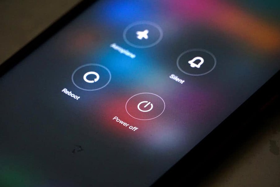 Người dùng thao tác khởi động lại trên smartphone