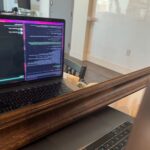 MacBook cũ đặt trước gương để webcam quan sát màn hình