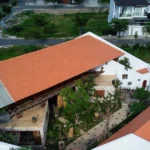 Mặt ngoài ngôi nhà nằm giữa khu vườn nhiều cây xanh ở Nha Trang