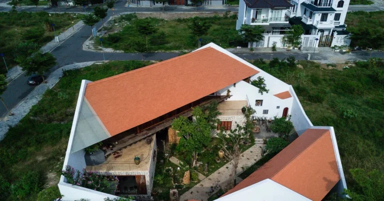 Mặt ngoài ngôi nhà nằm giữa khu vườn nhiều cây xanh ở Nha Trang