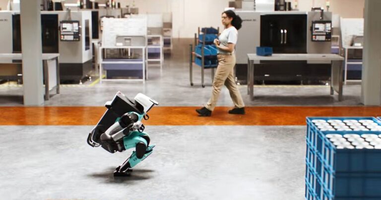 Robot hình người Digit 5 đứng trong không gian làm việc công nghiệp