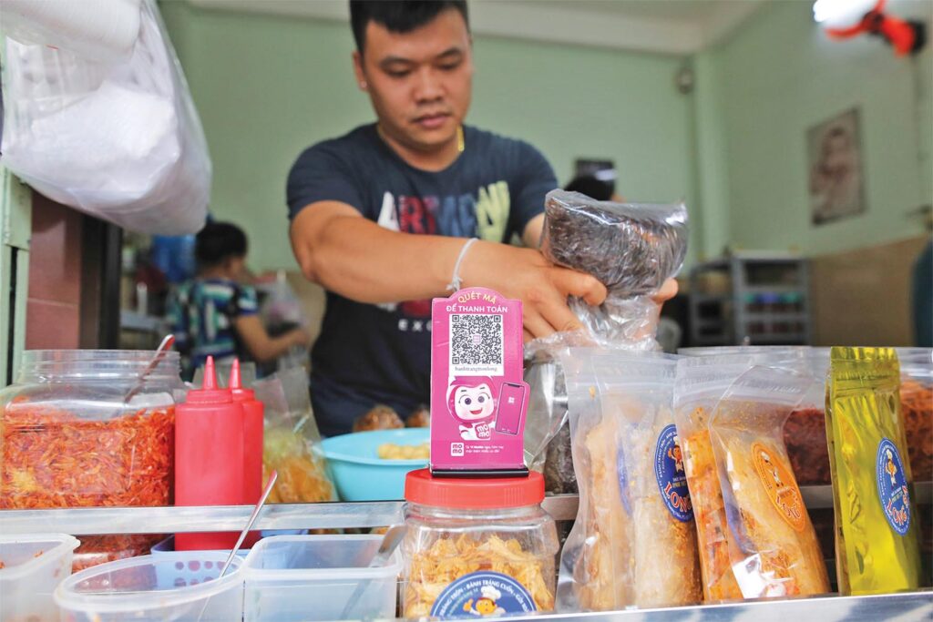 Người dân sử dụng điện thoại thanh toán các dịch vụ thiết yếu
